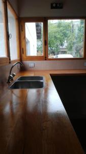 a kitchen with a sink and two windows at Departamento Los Inmigrantes in Esquel