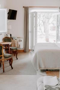 a bedroom with a bed and a table and chairs at Ponte Pedra - Melides Country House Adults Only in Melides