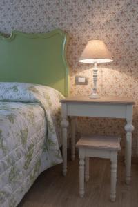 a lamp on a table next to a bed at DormidaNoi B&B in Civitanova Marche