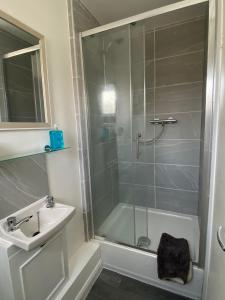 a bathroom with a shower and a sink and a bath tub at Four Seasons by the Sea in Peacehaven