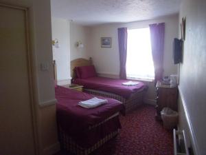a hotel room with two beds and a window at Hotel de Ville in Ramsgate