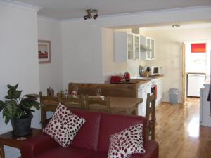 Seggat Farm Holiday Cottages في Kirktown of Auchterless: غرفة معيشة مع أريكة ومطبخ