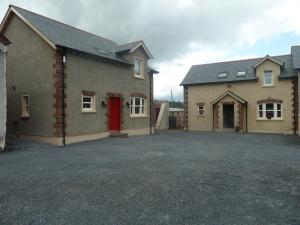 a house with a red door and a driveway at Oatlands Self Catering Lets in Hillsborough