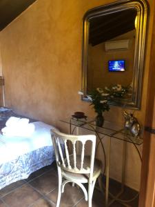 ein Schlafzimmer mit einem Bett, einem Stuhl und einem Spiegel in der Unterkunft Finca Vergel in Gata