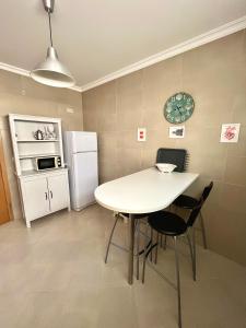 a kitchen with a table and chairs and a refrigerator at Arte de Marinheiro in Sesimbra