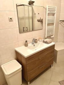 a bathroom with a sink and a toilet and a mirror at Arte de Marinheiro in Sesimbra