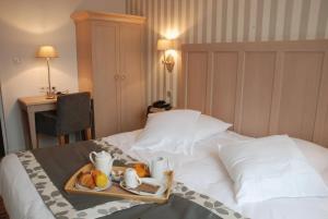 Łóżko lub łóżka w pokoju w obiekcie Hôtel Les Fleurs