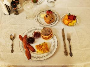 a table with two plates of breakfast food on it at The Weis Mansion Bed and Breakfast in Waterloo