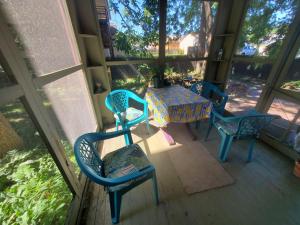 a table and chairs on a porch with a table at The Weis Mansion Bed and Breakfast in Waterloo