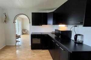 cocina con armarios negros y encimera negra en Apartments Reine Lofoten en Reine