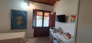 a bedroom with a bed and a desk and a television at Bungalow Coronas in Bonorva