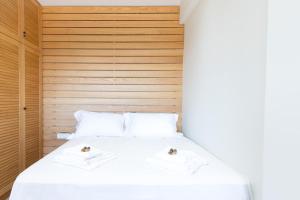 Una cama blanca con dos toallas encima. en Thea Studio, en Agios Padeleimon