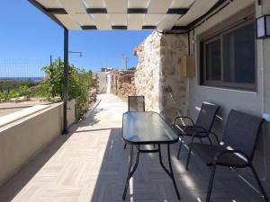 a table and chairs on the balcony of a building at Thea Studio in Agios Padeleimon