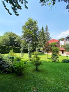 a yard with green grass and trees and a building at Brezovica Luxury Villa in Brezovicë