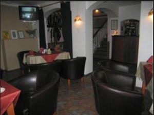 ein Restaurant mit schwarzen Ledersesseln, einem Tisch und einem Speisesaal in der Unterkunft Hotell De Tolly in Tõrva