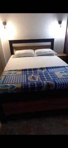 Una cama con una manta azul y blanca. en BAFFOUR STUDIO en Kumasi
