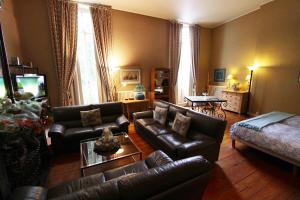 a living room with leather couches and a table at Home Fleuri Guesthouse in Bruges