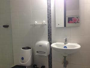 a bathroom with a sink and a toilet and a urinal at Hotel Sama in Montería