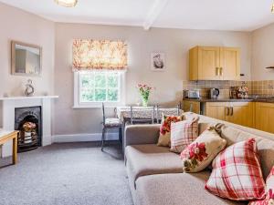 a living room with a couch and a kitchen at Riverside in Craven Arms