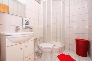 a white bathroom with a toilet and a shower at Apartments Ars Vivendi in Trogir +74 photos