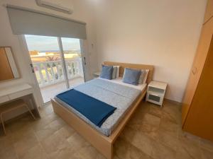 een slaapkamer met een bed en een groot raam bij Villa suncity Boutique Beachfront in Ayia Napa