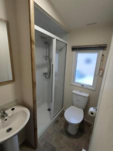 a bathroom with a shower and a toilet and a sink at 3 Bedroom Luxury Caravan - Vans With Business Sign Not Allowed in Port Seton +11 photos