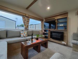 a living room with a couch and a fireplace at Luxury 3 Bedroom Caravan Near Edinburgh in Port Seton