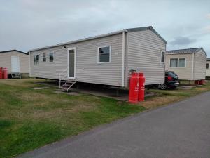 a trailer with a red fire hydrant in front of it at 3 Bedroom Luxury Caravan - Vans With Business Sign Not Allowed in Port Seton