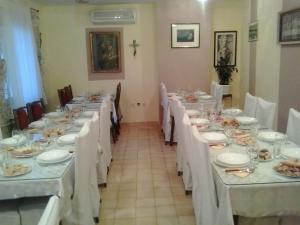 a long dining room with white tables and chairs at Guest House Mačun in Međugorje