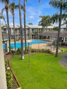 een uitzicht op een resort met een zwembad en palmbomen bij Mandurah Apartments Sunsets in Mandurah