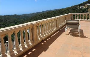 a chair sitting on a balcony with mountains in the background at Nice Home In Sant Cebria De Vallalt in Sant Cebrià de Vallalta +11 photos