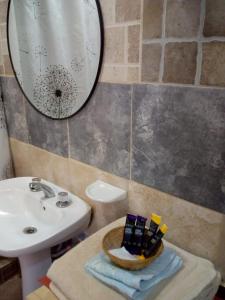 een badkamer met een wastafel en een spiegel bij Hotel de Campo Oeste Paraíso in La Ciénaga