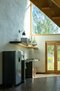 a kitchen with a stainless steel refrigerator and a window at Coconi House in Tuxpan de Rodríguez Cano