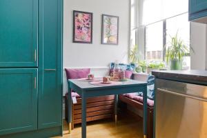 uma cozinha com uma mesa azul num quarto em Stylish London Getaway in the Heart of the City em Londres