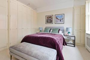 um quarto com uma cama com um cobertor roxo em Stylish London Getaway in the Heart of the City em Londres