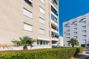 Un edificio alto con palmeras delante. en New Luxury Bella Apartment, en Split