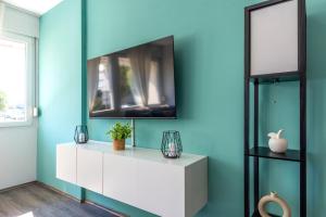 a living room with a tv on a blue wall at New Luxury Bella Apartment in Split