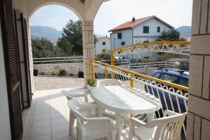 a white table and chairs on a balcony at Apartments with a parking space Grebastica, Sibenik - 4867 in Grebaštica