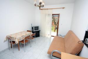 una sala da pranzo con tavolo, sedie e TV di Apartments with a parking space Grebastica, Sibenik - 4867 a Grebaštica
