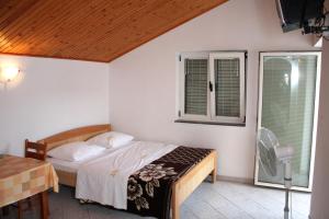 a bedroom with a bed and a table and a window at Apartments with a parking space Grebastica, Sibenik - 4867 in Grebaštica