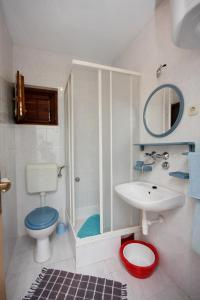 uma casa de banho branca com um WC e um lavatório em Apartments with a parking space Jezera, Murter - 5135 em Jezera