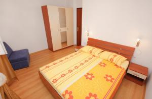 ムルテルにあるApartments with a parking space Murter - 5089のベッドルーム1室(黄色と赤の毛布付きのベッド1台付)