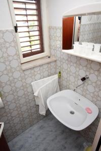 a bathroom with a white sink and a mirror at Apartments by the sea Jezera, Murter - 5074 in Jezera