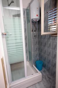 a shower with a glass door in a bathroom at Apartments by the sea Jezera, Murter - 5074 in Jezera