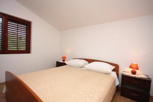 a bedroom with a bed and a window and two lamps at Apartments with parking space Jezera, Murter - 5109 in Jezera