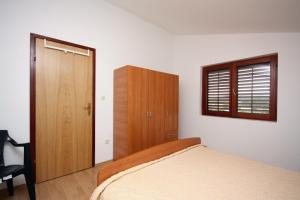 a bedroom with a bed and a wooden cabinet at Apartment Jezera 5109b in Jezera