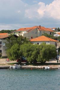 a group of buildings and trees next to the water at Apartments by the sea Jezera, Murter - 5063 in Jezera