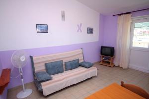 a living room with a couch and a tv at Apartments by the sea Jezera, Murter - 5063 in Jezera