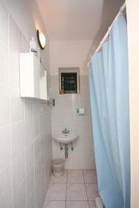 a bathroom with a sink and a shower curtain at Seaside holiday house Murter - 5092 in Murter