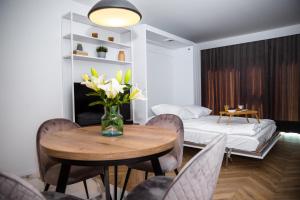 una camera con un tavolo con sedie e un letto di SMART Apartament typu studio BASEN & SPA Unia Residence a Lublino